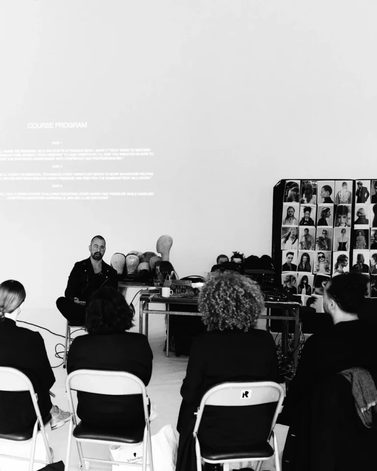 Pablo Kuemin teaching a seated class, the course programme projected on the wall behind him
