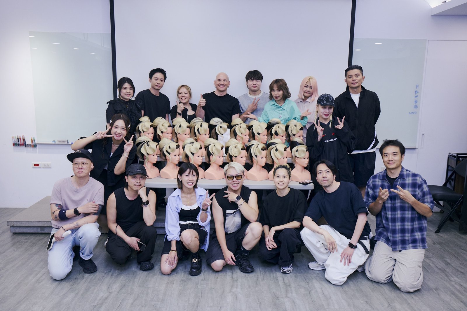 Jean-Baptiste Santens with his students and a row of styled mannequin heads after a Neo Couture class